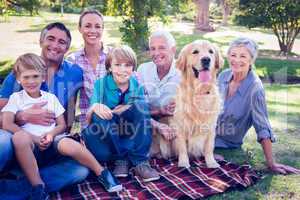 Happy family smiling at the camera with their dog