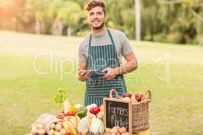 Handsome farmer using his tablet