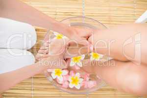 woman washing her feet in a bowl of flower