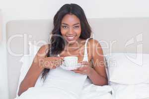 Relaxed woman drinking coffee in bed