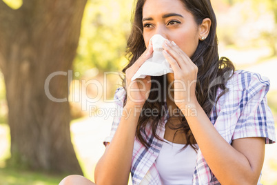 Pretty brunette blowing her nose