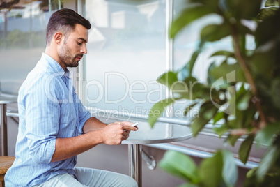 Attentive businessman sending text message