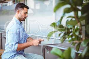 Attentive businessman sending text message