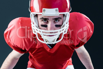 A serious american football player taking his helmet looking at