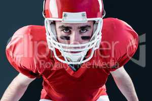 A serious american football player taking his helmet looking at