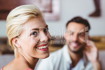 Couple with coffee cup sitting on sofa