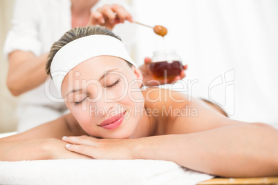 Therapist waxing womans back at spa center