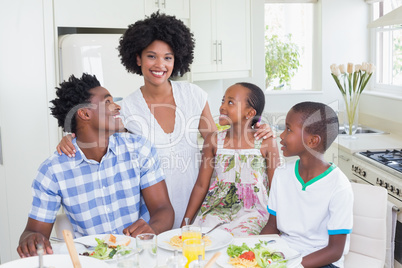 Happy family sitting down to dinner together