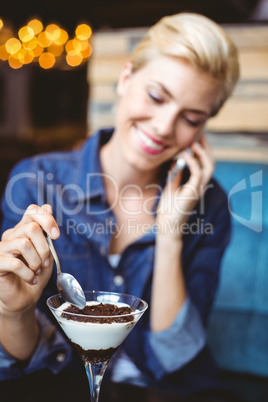 Smiling blonde eating a creamy chocolate