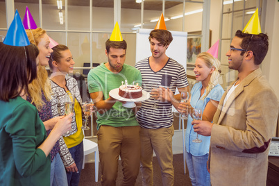 Businessman blowing candles on her birthday cake