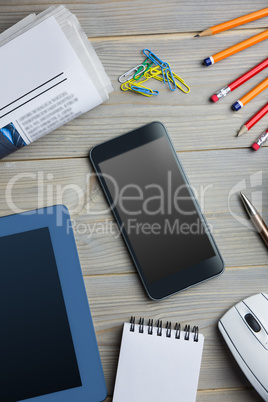 Smartphone next to the newspaper notepad tablet and pen