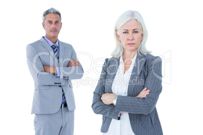 Smiling businesswoman and man with arms crossed