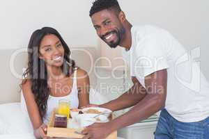 Relaxed couple having breakfast in bed together