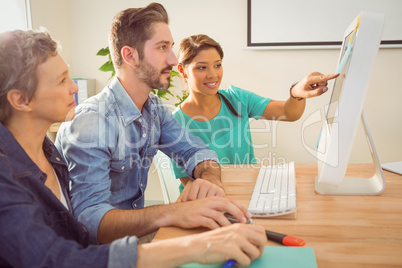 Colleagues using laptop at office