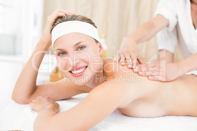 Pretty blonde enjoying a massage smiling at camera