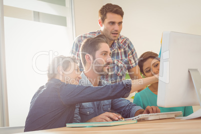 Colleagues using laptop at office