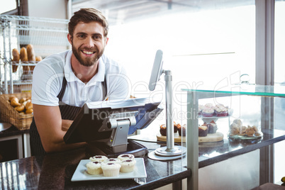 Smiling worker posing behind the counter