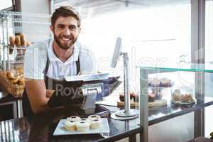 Smiling worker posing behind the counter