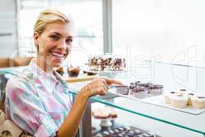 Pretty woman pointing at cup cakes