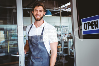 Smiling worker putting up open sign