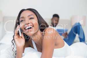 Relaxed couple using technology on bed