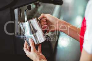 A barista using the coffee machine