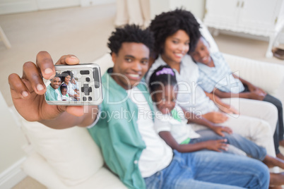 Happy family taking a selfie on the couch