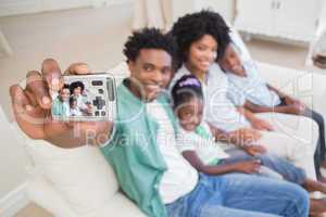 Happy family taking a selfie on the couch