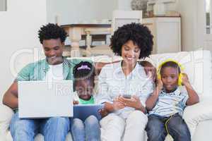 Happy family using technologies on the couch