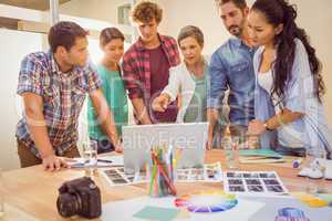 Happy creative business team using laptop in meeting