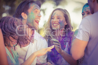 Friends having fun with powder paint in the park