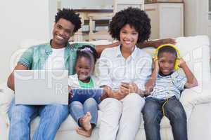 Happy family using technologies on the couch