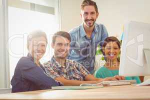 Colleagues using laptop at office