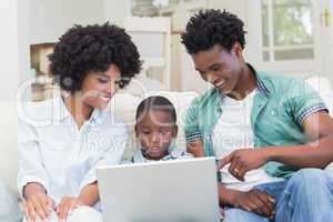 Happy family on the couch with laptop