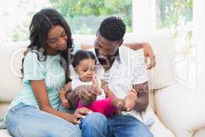 Happy couple with their baby girl on couch