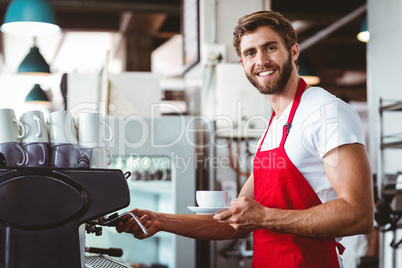Handsome barista preparing a cup of coffee