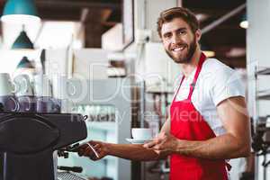 Handsome barista preparing a cup of coffee