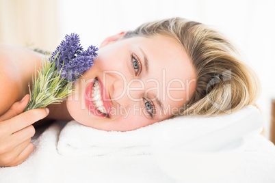 Beautiful blonde lying on massage table with lavanda