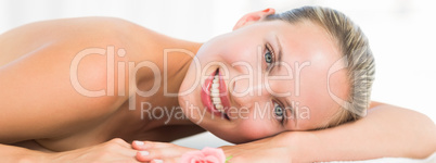 Peaceful blonde lying on towel smiling at camera