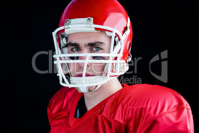 Portrait of a serious american football player taking his helmet