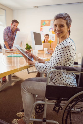Creative businesswoman in wheelchair using a tablet