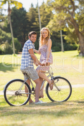 Young couple on a bike ride looking at camera