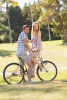 Young couple on a bike ride looking at camera