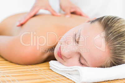 Pretty blonde enjoying a massage smiling at camera