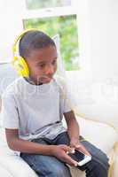 Little boy listening to music on the couch