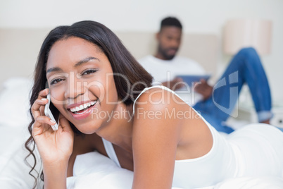 Relaxed couple using technology on bed