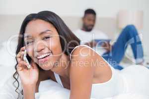 Relaxed couple using technology on bed