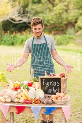 Handsome farmer standing at his stall