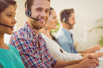 Smiling businessman working in a call centre