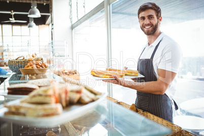 happy worker holding sandwiches